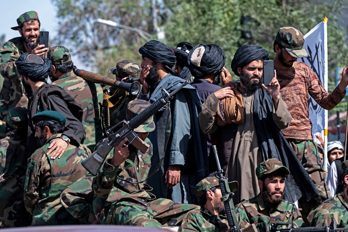 Armed Taliban security personnel ride a vehicle convoy as they parade near the US embassy in Kabul (AFP via Getty Images)