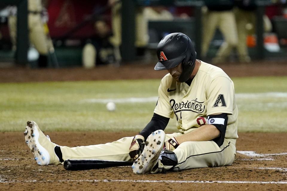 Arizona Diamondbacks' Jordan Luplow pauses at home plate after fouling a pitch off his foot during the fifth inning of a baseball game against the Los Angeles Dodgers, Friday, May 27, 2022, in Phoenix. (AP Photo/Ross D. Franklin)