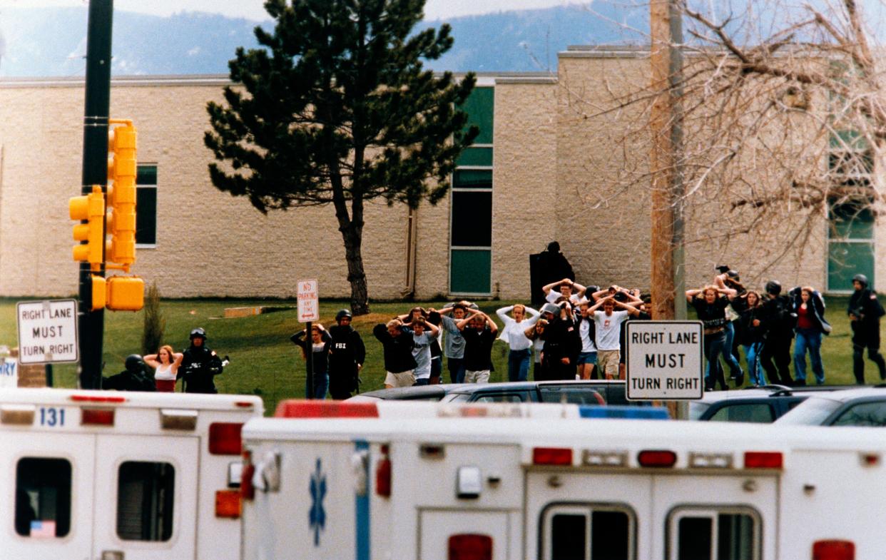 Students run out of Columbine High School as two gunmen went fatally shot 12 students and a teacher on April 20, 1999.