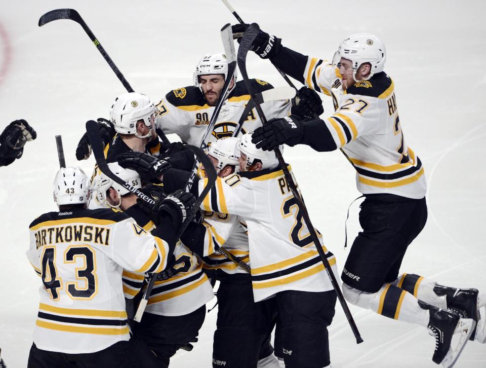 Boston Bruins' Matt Fraser is mobbed by teammates after scoring the game winning goal against the Montreal Canadiens during the first overtime period in Game 4 in the second round of the NHL Stanley Cup playoffs Thursday, May 8, 2014, in Montreal. (AP Photo/The Canadian Press, Ryan Remiorz)