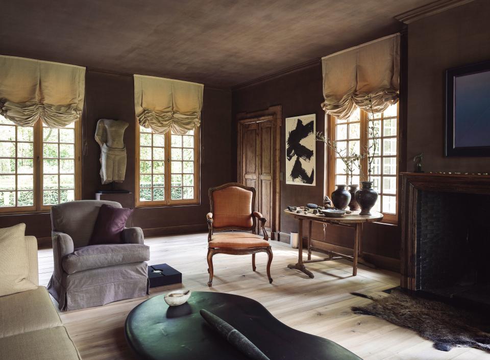 “Everything is painted with old lime techniques and mineral-based paints mixed with my own creativity,” says Dankers. He incorporated dirt from his father’s garden to create the earthy brown walls in the main living room, noting that the room’s cozy hues and larger fireplace make it more suitable for the winter than the orangerie.