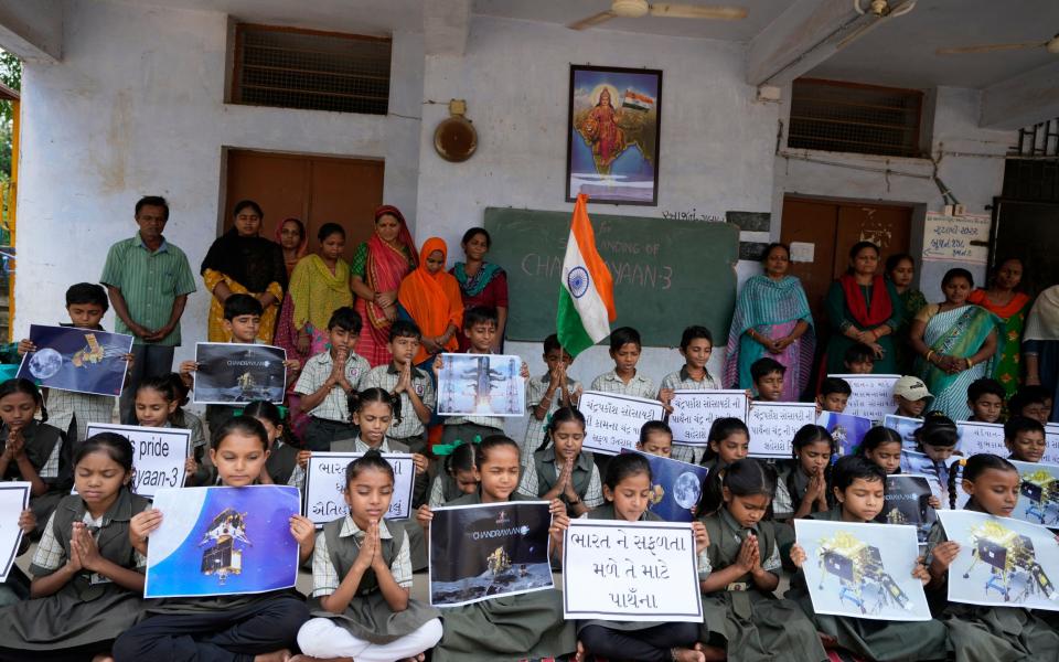 Students pray for the successful landing of India's moon craft Chandrayaan-3 at a school in Ahmedabad, India