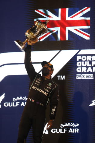 Mercedes driver Lewis Hamilton of Britain celebrates on the podium after winning the Bahrain Formula One Grand Prix at the Bahrain International Circuit in Sakhir, Bahrain, Sunday, March 28, 2021. (Lars Baron, Pool via AP)