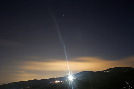 FILE PHOTO: A ray of light from a lamppost iluminates the diggers and trucks at the area where Julen, a Spanish two-year-old boy fell into a deep well four days ago when the family was taking a stroll through a private estate, in Totalan, southern Spain, January 17, 2019. REUTERS/Jon Nazca/File Photo