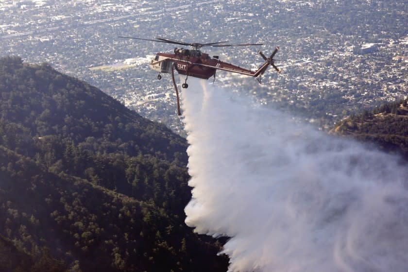 A helicopter makes a water drop on a fire near the Mt. Wilson Observatory in the Angeles National Forest northeast of Los Angeles.