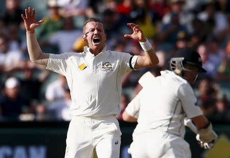 Australia's Peter Siddle (L) reacts as New Zealand's Tom Latham hits a shot during the second day of the third cricket test match at the Adelaide Oval, in South Australia, November 28, 2015. REUTERS/David Gray