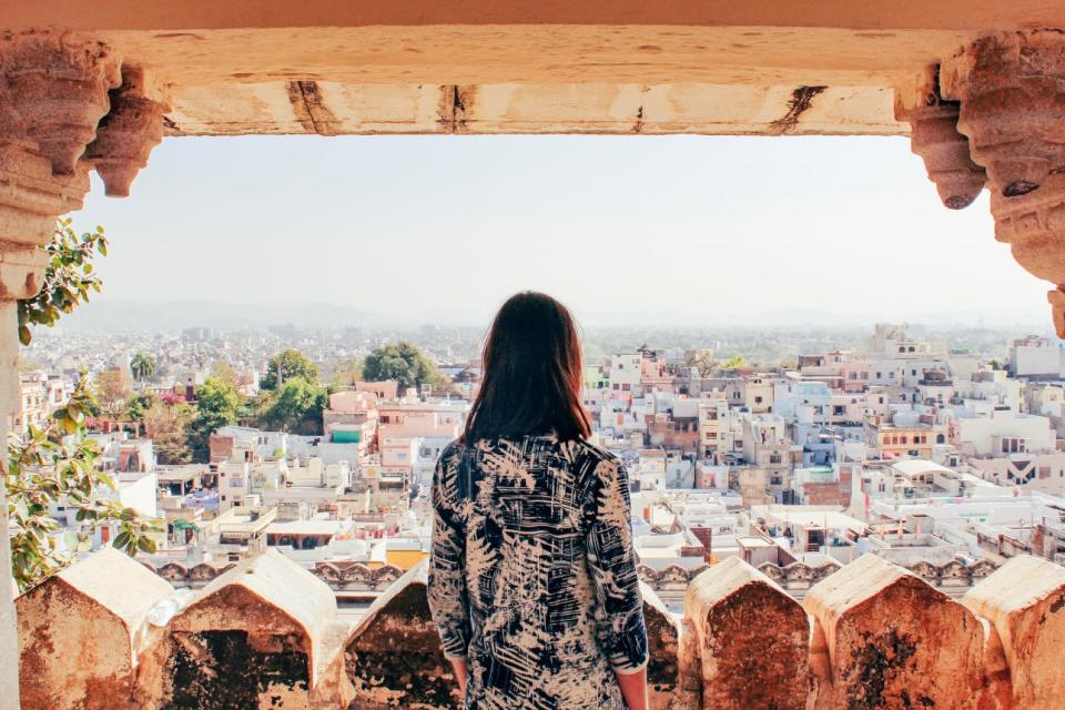 A woman looks out over the city of Udaipur