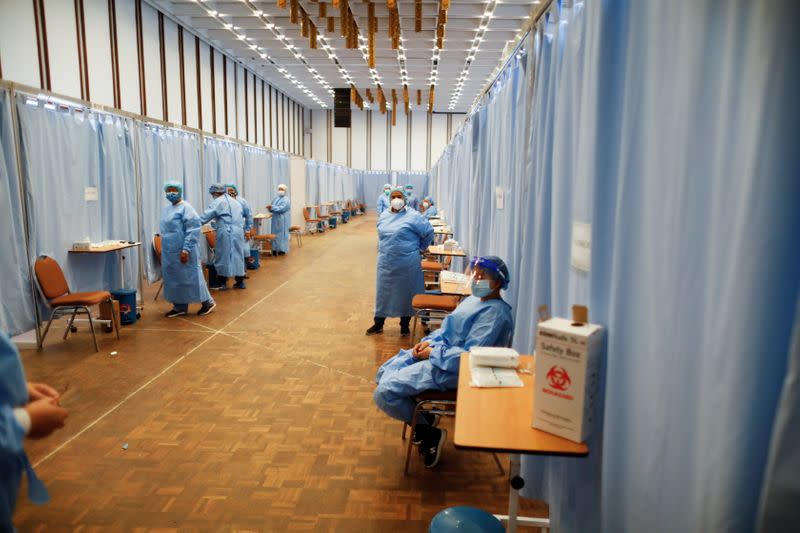 Health workers wait for the people who are going to receive their first dose of Russia's Sputnik V vaccine against the coronavirus disease (COVID-19), in Caracas