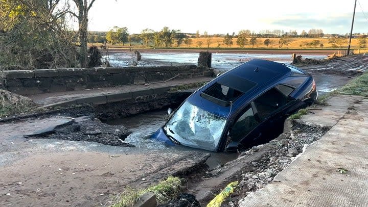 Car stuck in collapsed bridge as Storm Babet batters Scotland (PA)