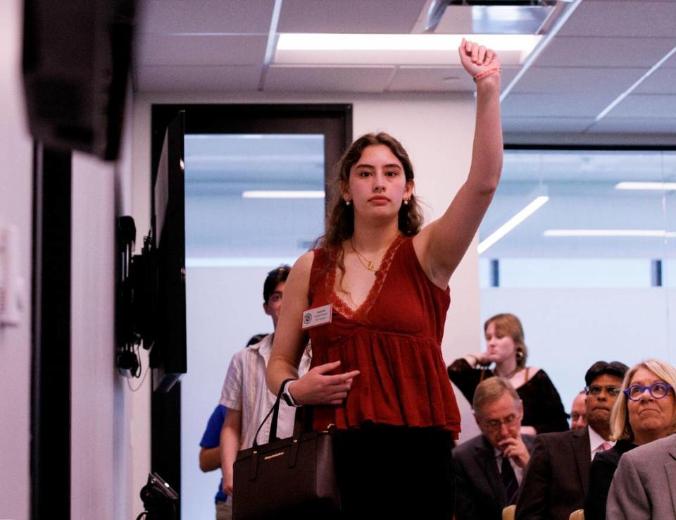 N.C. State junior Naila Din raises a fist while exiting a UNC System Board of Governors meeting on Thursday, May 23, 2024, in Raleigh, N.C. following the board’s approval of a policy that repeals DEI requirements across the university system.