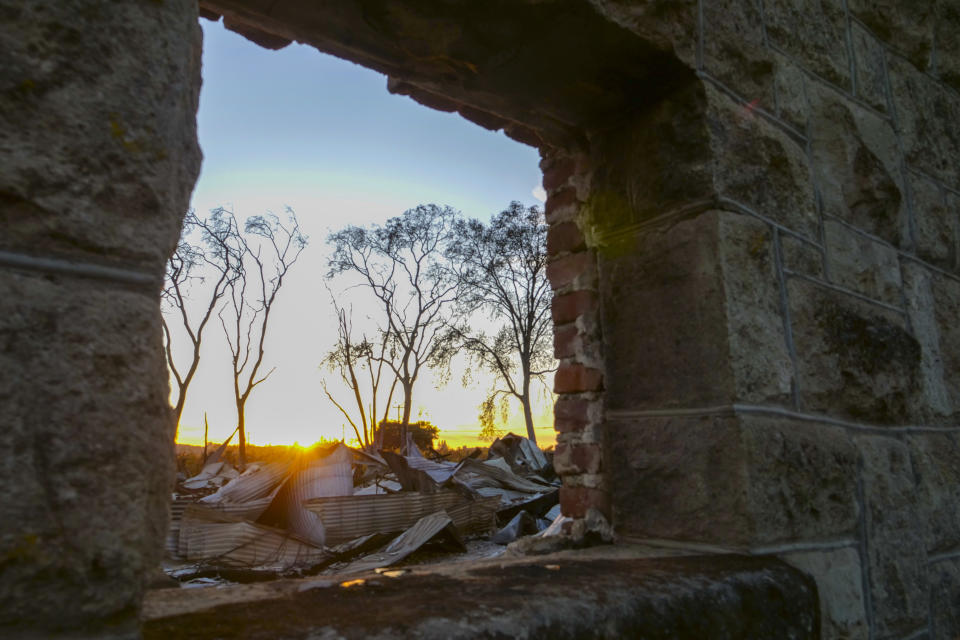 In this Tuesday Nov. 5, 2019, photo, the sunsets across the destruction of the main building that was built in 1869 which became the Soda Rock Winery in Healdsburg, Calif. In the end, the loss from the Kincade Fire was not as great for many reasons, from lessons firefighters learned and more precise wind forecasts to a bit of luck. Fire crews fought like mad to save places like the town of Windsor, just north of Santa Rosa, but were unable to stop the flames from overtaking some homes and other structures, including this old general store and post office built in 1869 in Healdsburg that had become the main building for the Soda Rock Winery. (AP Photo/Lacy Atkins)