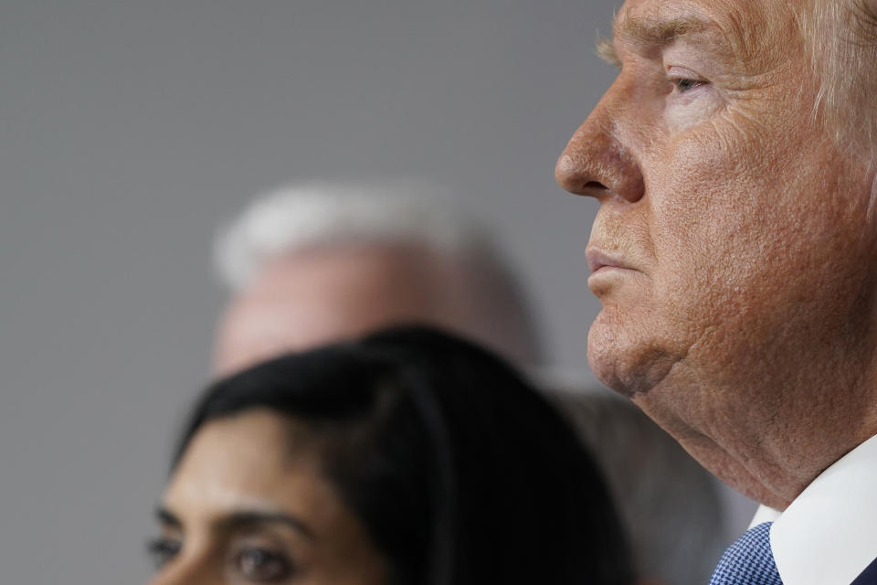 President Donald Trump and Administrator of the Centers for Medicare and Medicaid Services Seema Verma listen during a press briefing with the coronavirus task force, in the Brady press briefing room at the White House, Monday, March 16, 2020, in Washington. (AP Photo/Evan Vucci)