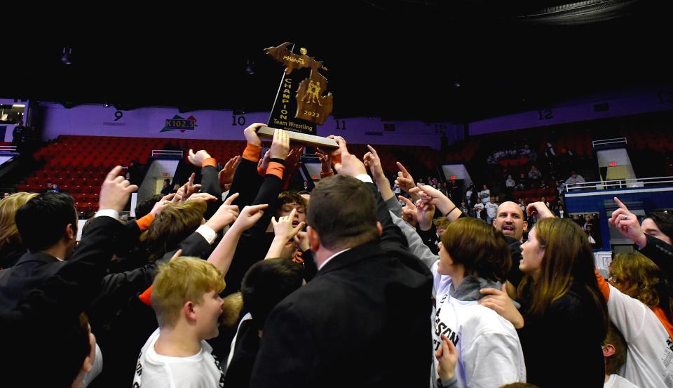 The Hudson Tigers varsity wrestling team celebrates winning the Division 4 state championship after defeating New Lothrop 47-13 Saturday at Wings Event Center in Kalamazoo. The Tigers finished the wrestling season with a 22-4 record.