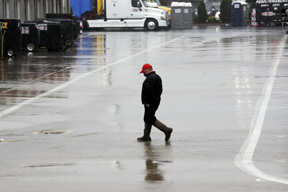 A man walks through the infield as rain falls before a NASCAR Cup Series auto race at Charlotte Motor Speedway Wednesday, May 27, 2020, in Concord, N.C. (AP Photo/Gerry Broome)