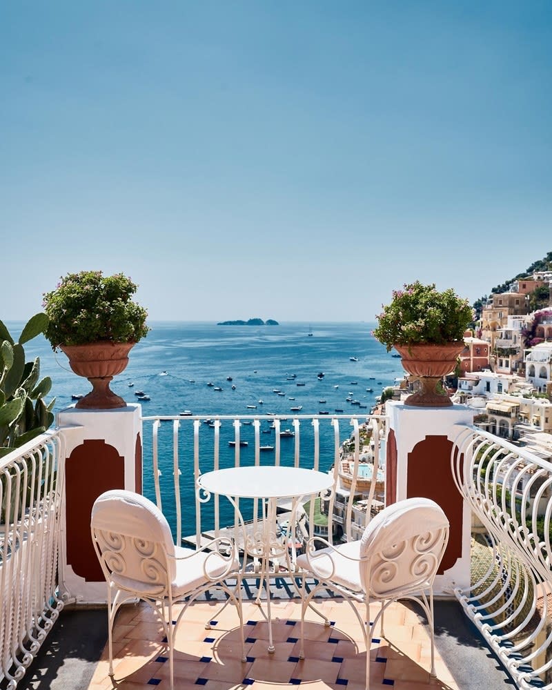 Balcony with a small table and chairs overlooking the scenery of the Amalfi Coast