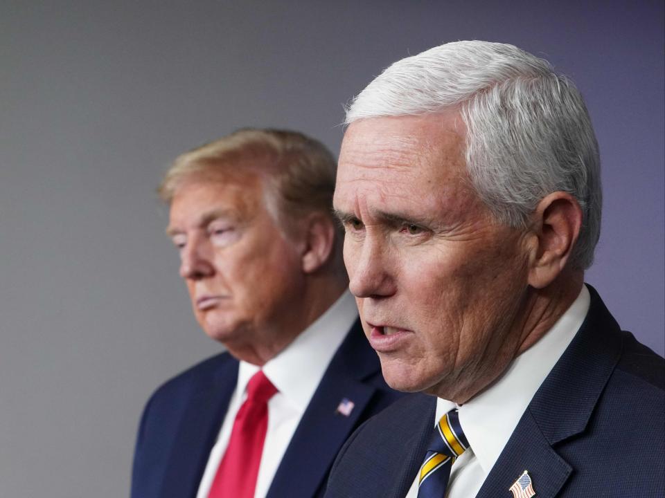 El presidente de Estados Unidos, Donald Trump, escucha al vicepresidente de Estados Unidos, Mike Pence, hablar durante la sesión informativa diaria sobre el nuevo coronavirus. (AFP via Getty Images)