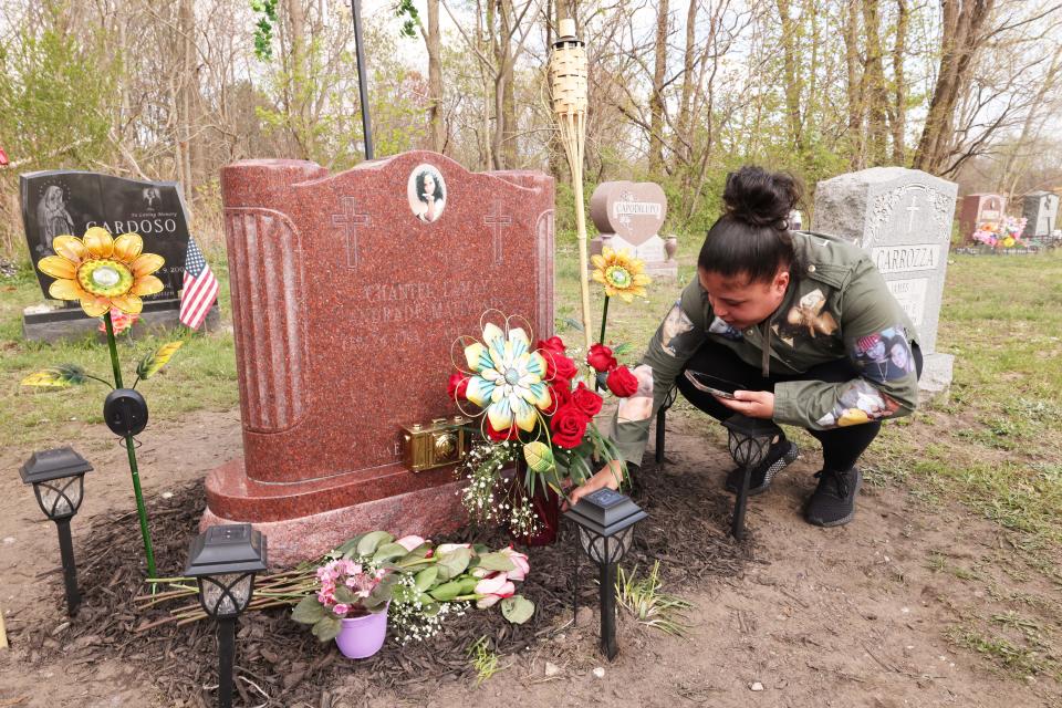 Tiffany Andrade, sister of the late Chantel Matiyosus at the Calvary Cemetery in Brockton, where remnants of the pink paint that was used to deface Chantel's headstone can be seen, on Wednesday, April 26, 2023.