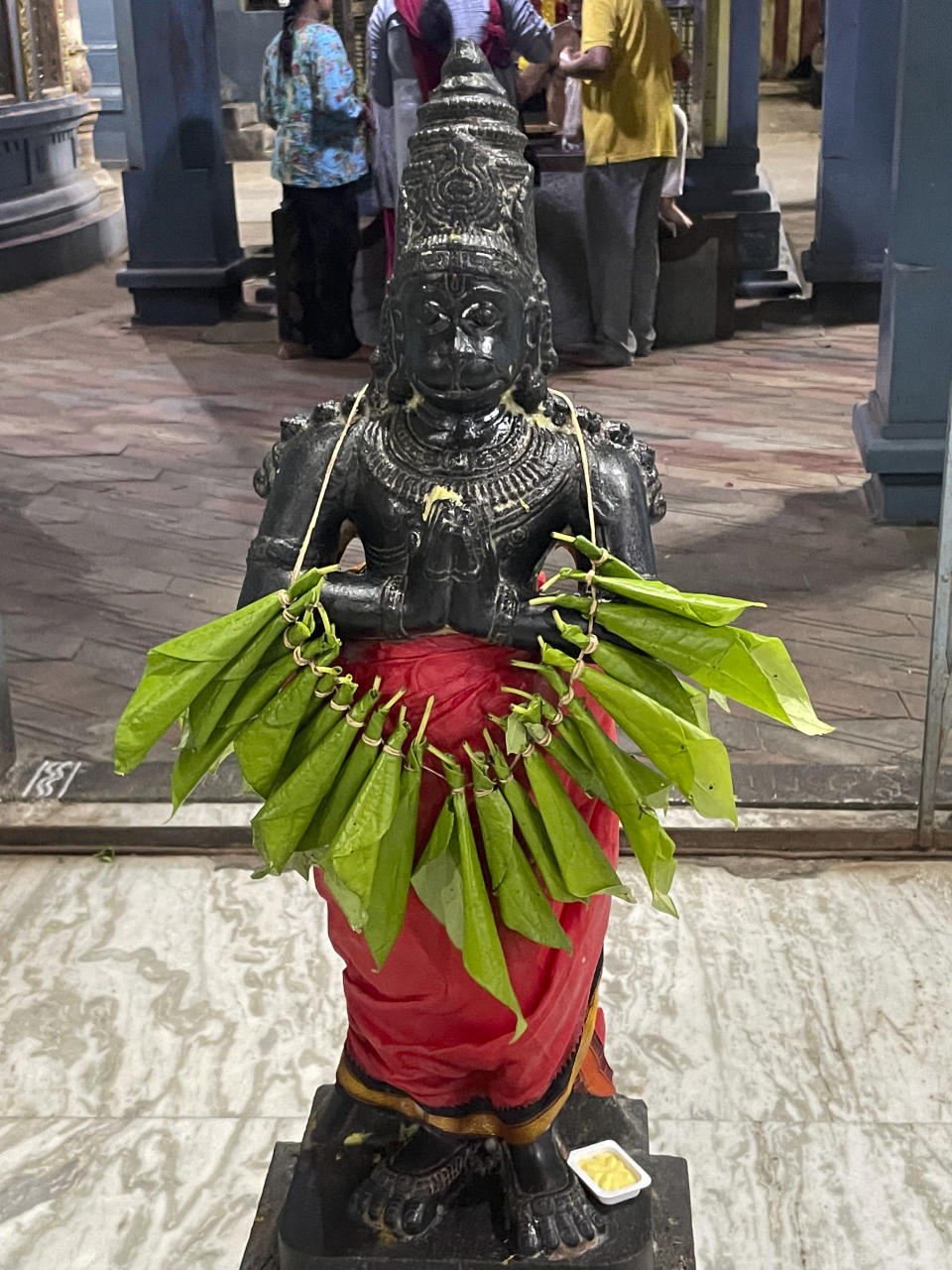 Devotees offer betel leaf garlands to the deity known as Hanuman or Anjaneya at the Sri Lakshmi Narasimha Navaneetha Krishnan Temple in Chennai, India, on Nov. 28, 2022. The deity is popular among U.S. visa seekers as "America Anjaneya" or "Visa Anjaneya" because they believe praying to him will make the process successful and hassle-free. (AP Photo/Deepa Bharath)