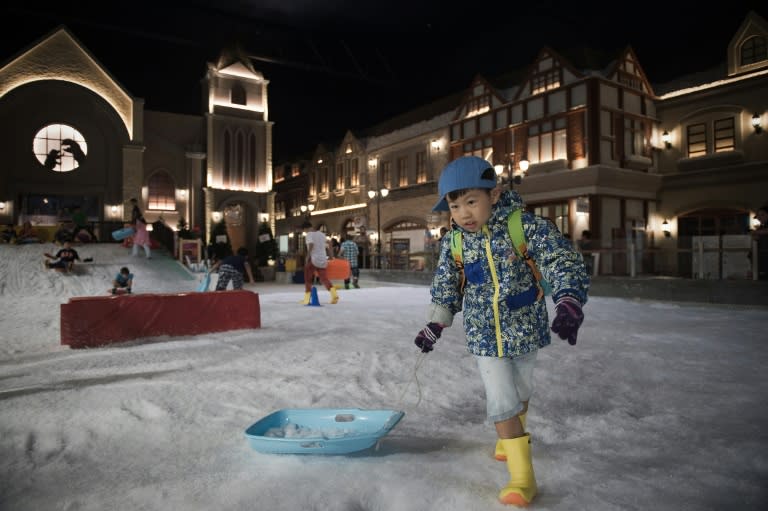 A boy pulls on his sled at Snow Town in Bangkok