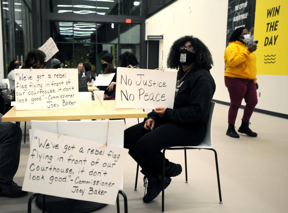 Unique Morgan Dunston, right, participates in a sit-in protest in her hometown of Albertville, Ala., on Wednesday, Dec. 9, 2020. Dunston has been leading regular demonstrations since August against a Confederate monument and flag located on the lawn of the Marshall County Courthouse. (AP Photo/Jay Reeves)