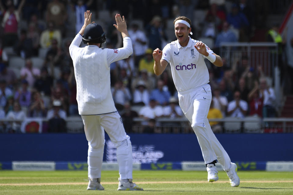 England's Stuart Broad, right, celebrates the dismissal of Australia's Travis Head during the first day of the fourth Ashes cricket Test match between England and Australia at Old Trafford in Manchester, England, Wednesday, July 19, 2023. (AP Photo/Rui Vieira)