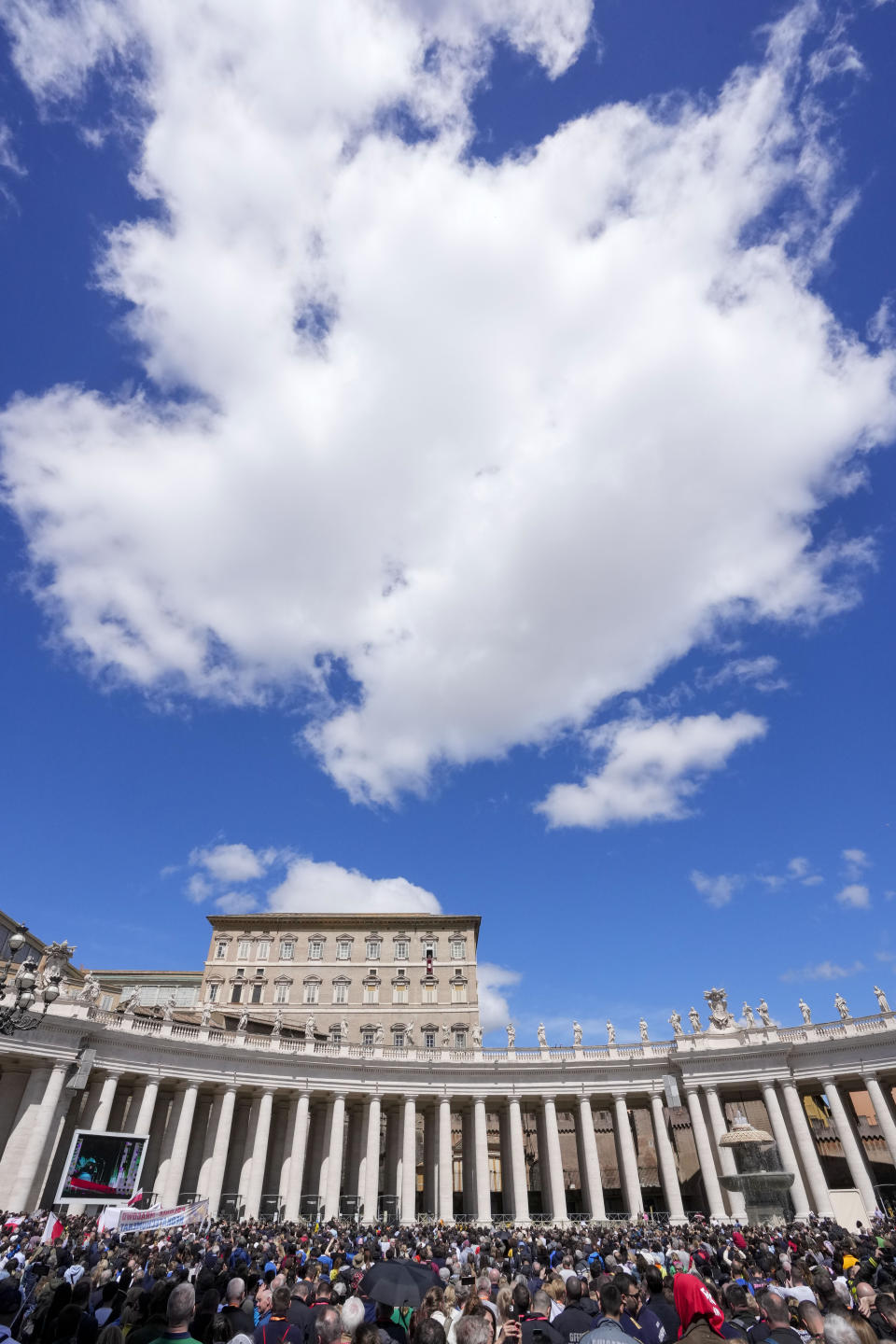 People gather as Pope Francis recites the Regina Coeli noon prayer from the window of his studio overlooking St.Peter's Square, at the Vatican, Sunday, April 16, 2023. (AP Photo/Andrew Medichini)