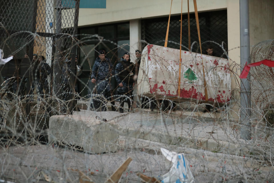 Lebanese riot police stand guard as an engineering unit installs a concrete wall near the Lebanese government headquarters, a day after the new Lebanese cabinet was announced, in Beirut, Lebanon, Wednesday, Jan. 22, 2020. A new Cabinet has been announced last night in crisis-hit Lebanon, breaking a months-long impasse amid mass protests against the country's ruling elite. (AP Photo/Hassan Ammar)