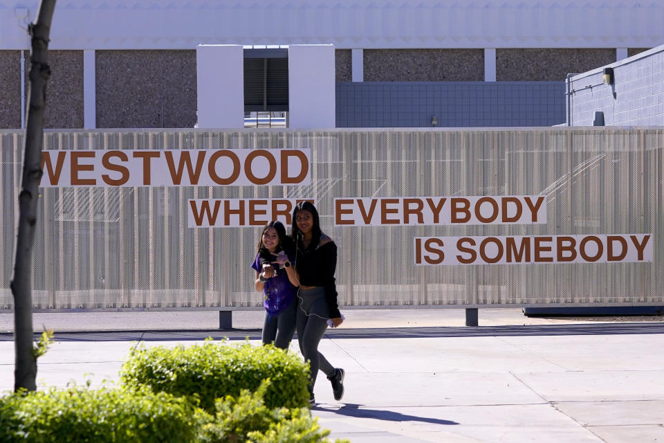 Westwood High School students make their way to class, Tuesday, Oct. 18, 2022 in Mesa, Ariz. Like many school districts across the country, Mesa has a teacher shortage due in part due to low morale and declining interest in the profession. Five years ago, Mesa allowed Westwood to pilot a program to make it easier for the district to fill staffing gaps, grant educators greater agency over their work and make teaching a more attractive career. The model, known as team teaching, allows teachers to combine classes and grades rotating between big group instruction, one-on-one interventions, small study groups or whatever the team agrees is a priority each day. (AP Photo/Matt York)