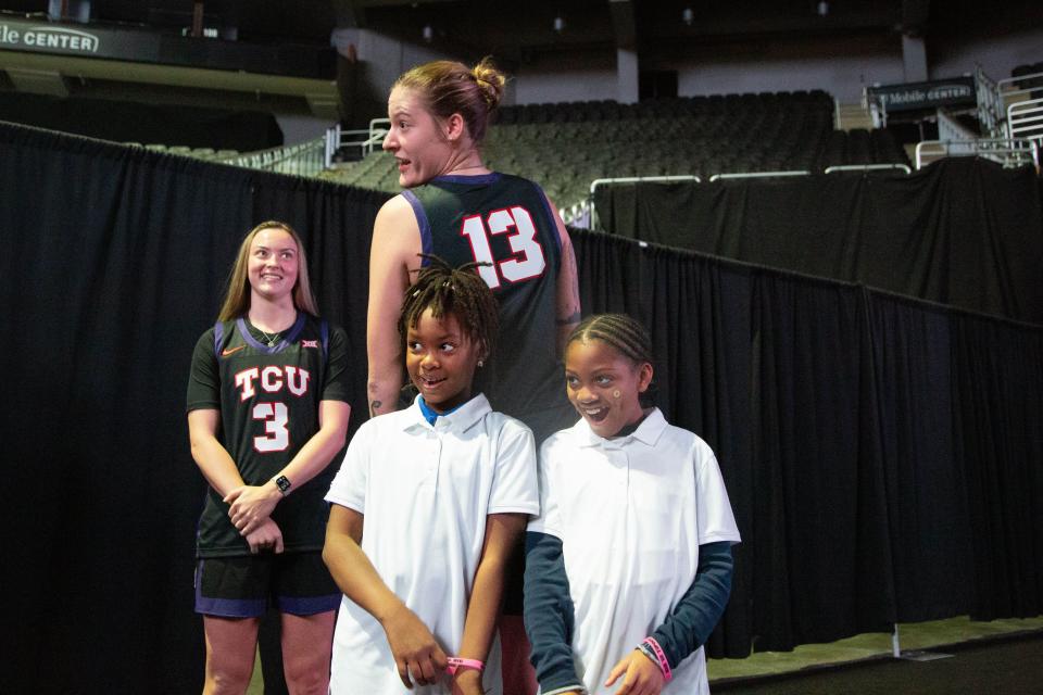 TCU player Sedona Prince, a former Texas and Oregon player who has transferred to the Horned Frogs, compares heights with junior reporters at Big 12 basketball media days on Tuesday in Kansas City. Prince is a 6-foot-7 forward.