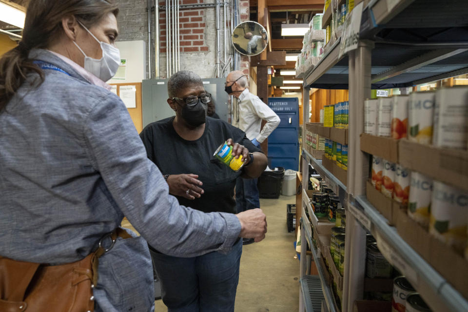 Helena Smith, center, of Washington, chooses a food item while shopping at Bread for the City, Wednesday, May 10, 2023, a food pantry in Washington. The formal end of the national Public Health Emergency on Thursday marks the end of several U.S. pandemic-era emergency support program, from extra food assistance to automatic enrollment in Medicaid. "I like this a lot because they give us a variety of fruit," says Smith, "instead of just cans." (AP Photo/Jacquelyn Martin)