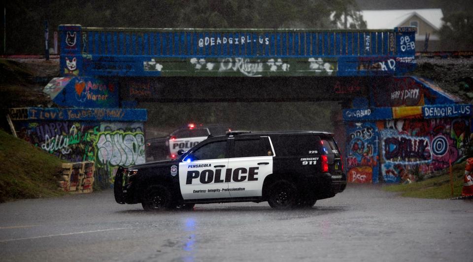 Two Pensacola Police cruisers close 17th Avenue at Graffiti Bridge to motorists due to road flooding caused by a line of intense rain storms on Wednesday, April 10, 2024.