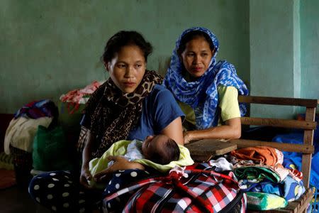 A evacuated mother Rohanifa carries her 2-weeks-old baby Raifah who was born at the evacuation center outside Marawi, while government forces still fighting insurgents from the Maute group in Marawi, Philippines June 26, 2017. REUTERS/Jorge Silva