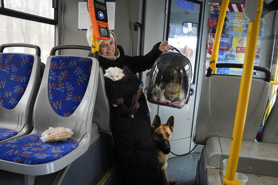 A woman shows her pets as she waits in the bus while sappers operate at the site of a Russian attack in Kyiv, Ukraine, Tuesday, Jan. 23, 2024. (AP Photo/Efrem Lukatsky)