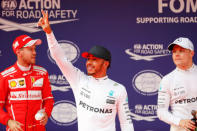 Formula One - F1 - Chinese Grand Prix - Shanghai, China - 08/04/17 - Mercedes driver Lewis Hamilton (C) of Britain reacts after setting pole position in qualifying alongside team mate Valtteri Bottas (R) of Finland and Ferrari's Sebastian Vettel of Germany at the Shanghai International Circuit. REUTERS/Aly Song
