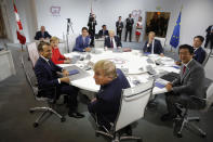 French President Emmanuel Macron, left, U.S. President Donald Trump,center, Japan's Prime Minister Shinzo Abe, second right, Britain's Prime Minister Boris Johnson, rear center, German Chancellor Angela Merkel , second left, Canada's Prime Minister Justin Trudeau, Italy's Prime Minister Giuseppe Conte, right, and European Council President Donald Tusk attend a G7 working session on "International Economy and Trade, and International Security Agenda" during the G7 summit in Biarritz, southwestern France, Saturday Aug. 25, 2019. (Philippe Wojazer/Pool via AP)