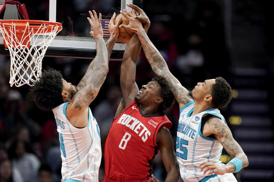 Charlotte Hornets center Nick Richards, left, and forward P.J. Washington, right, block the shot of Houston Rockets forward Jae'Sean Tate (8) during the second half of an NBA basketball game, Wednesday, Nov. 1, 2023, in Houston. (AP Photo/Eric Christian Smith)