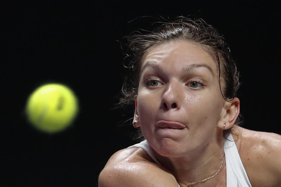 In this Friday, Nov. 1, 2019, file photo, Simona Halep of Romania eyes on the ball as she plays against Karolina Pliskova of the Czech Republic during the WTA Finals Tennis Tournament at the Shenzhen Bay Sports Center in Shenzhen, China's Guangdong province. (AP Photo/Andy Wong, File)