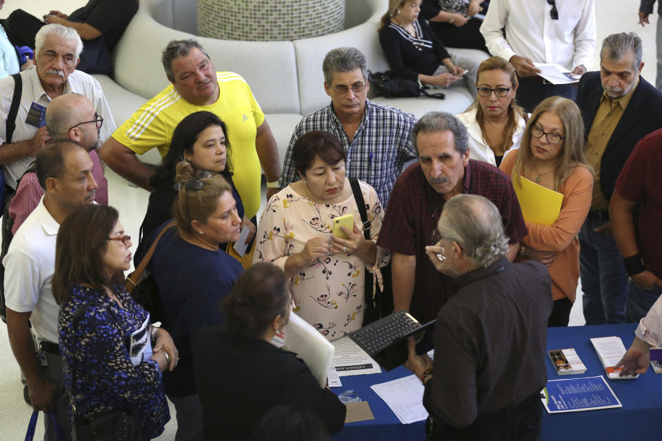 FILE - In this Sept. 18, 2019, file photo people inquire about temporary positions available for the 2020 Census during a job fair designed for people fifty years or older in Miami. On Friday, Dec. 6, the U.S. government issues the November jobs report. (AP Photo/Lynne Sladky, File)