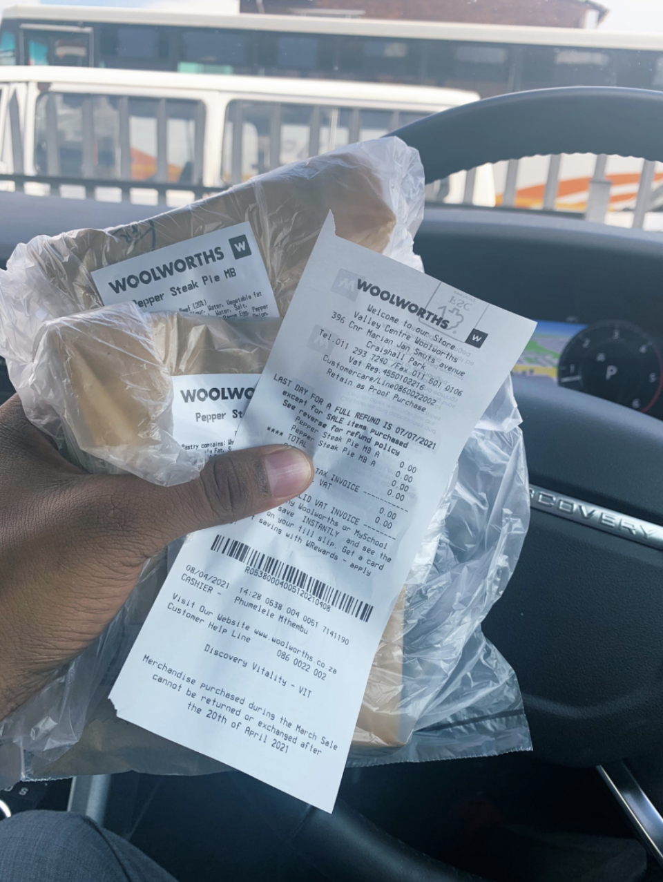 Photo of a hand holding two pies and a Woolworths SA receipt.