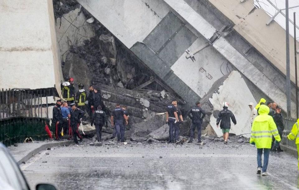 Rescuers next to the bridge show the scale of the disastrous collapse on Tuesday. (Rex)