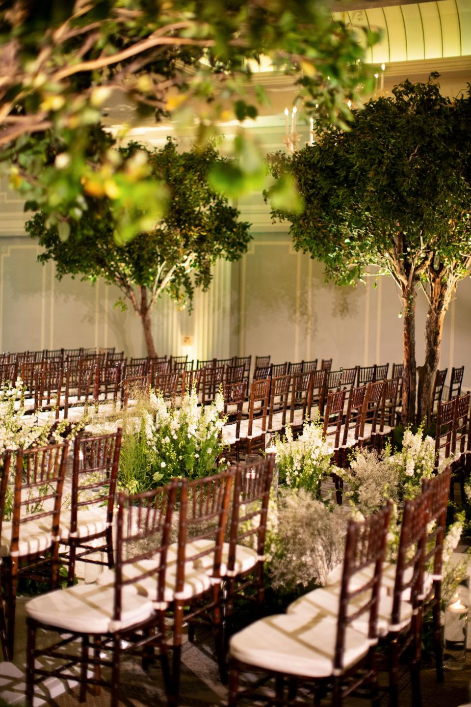 Chiavari chairs, live trees, and wild delphinium.