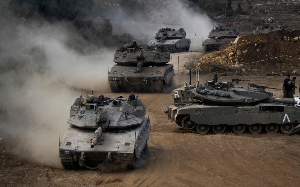 Israeli army tanks manoeuvre in a staging area in northern Israel near the Israel-Lebanon border