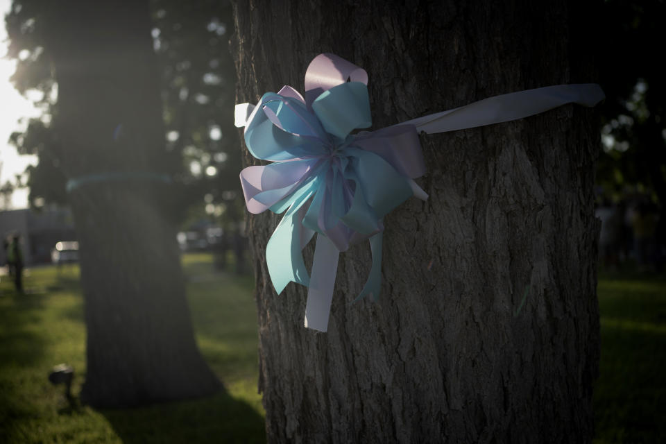 Sunlight illuminates ribbons that decorate trees at a memorial site in the town square on Friday, May 27, 2022, in Uvalde, Texas days after a deadly school shooting took the lives of 19 children and two teachers. (AP Photo/Wong Maye-E)
