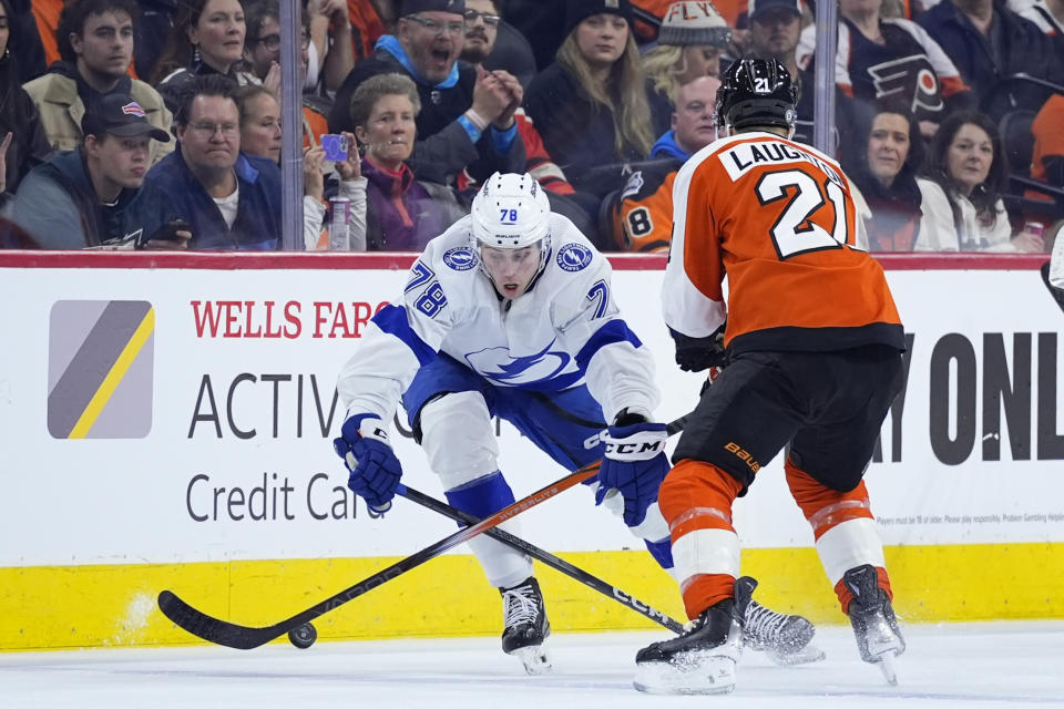 Tampa Bay Lightning's Emil Martinsen Lilleberg, left, and Philadelphia Flyers' Scott Laughton battle for the puck during the second period of an NHL hockey game, Tuesday, Jan. 23, 2024, in Philadelphia. (AP Photo/Matt Slocum)