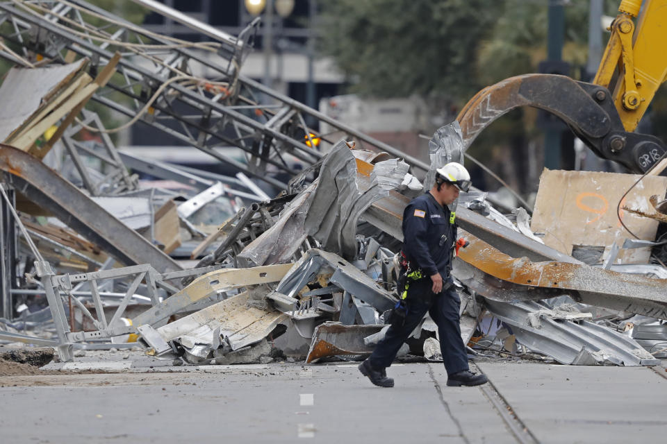 FILE - In this Wednesday, Oct. 16, 2019 file photo, A worker walks in front of rubble in the street at the site of the Hard Rock Hotel in New Orleans. Dozens of protesters marched from the site of the partially collapsed Hard Rock Hotel on the edge of the French Quarter to City Hall on Friday, Jan. 24, 2020 demanding that something be done about the hotel and that the two bodies still inside be recovered. (AP Photo/Gerald Herbert, File)