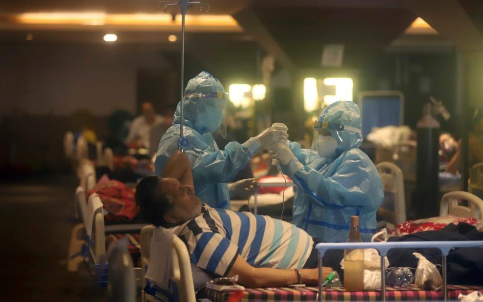 Health workers attend to Covid-19 patients at a makeshift hospital in New Delhi, India,  - STR/AP