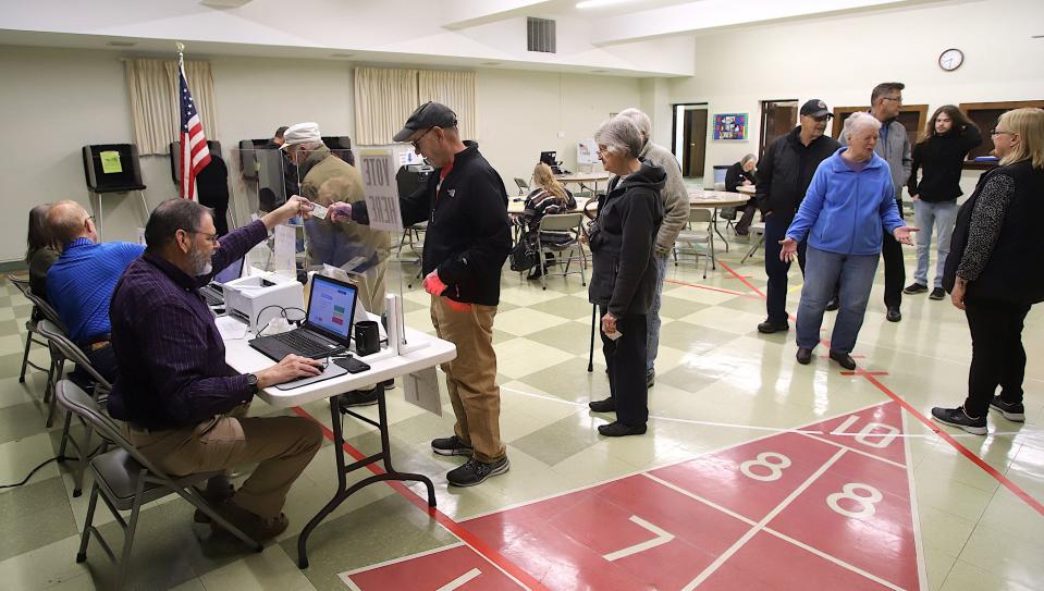 Dale Alison checks in voters Tuesday at Oak Street Baptist Church in Burlington.