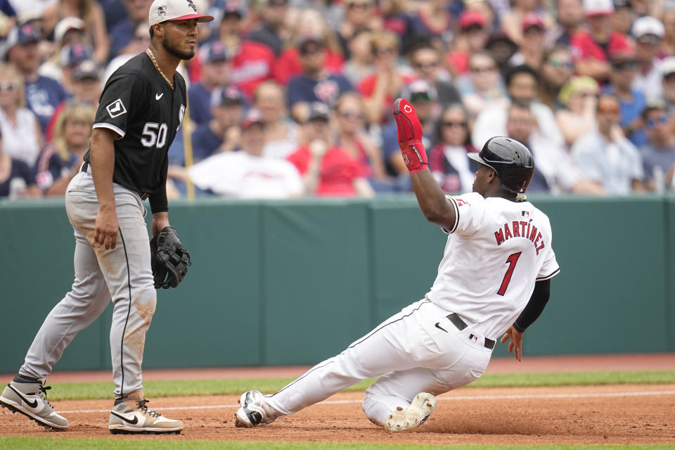 Cleveland Guardians' Angel Martinez (1) advances to third base in front of Chicago White Sox third baseman Lenyn Sosa on a fly ball hit for an out by Cleveland Guardians' José Ramírez in the third inning of a baseball game Thursday, July 4, 2024, in Cleveland. (AP Photo/Sue Ogrocki)