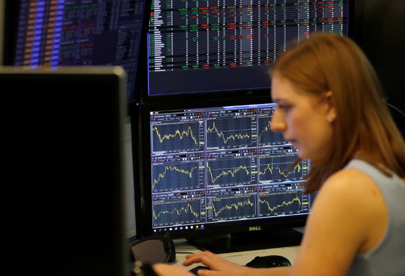 A financial trader works at their desk at CMC Markets in the City of London