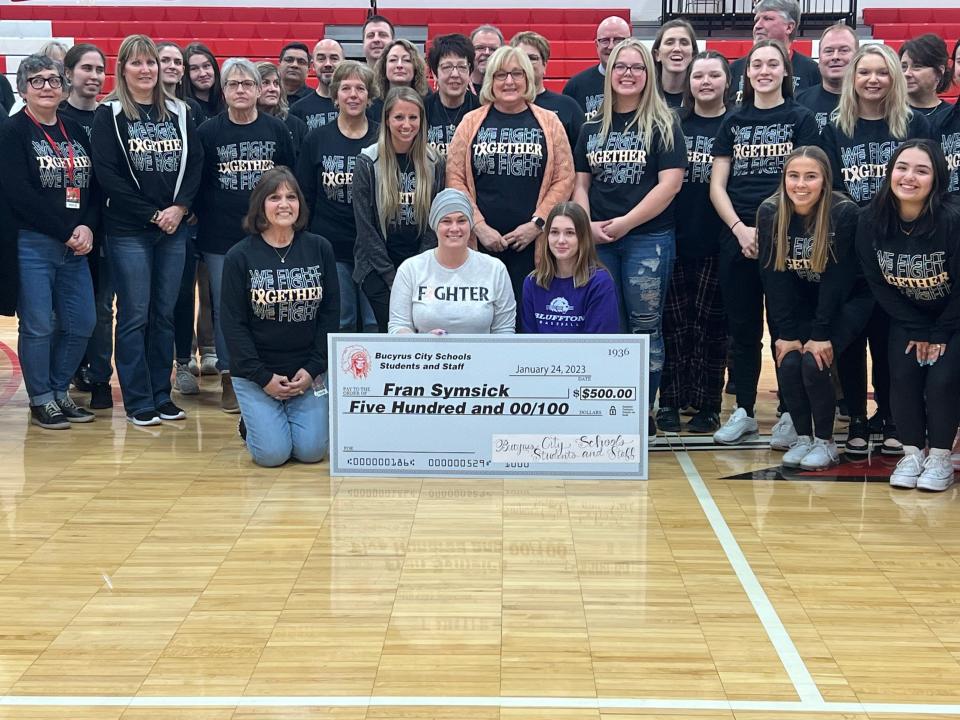 Bucyrus High School secretary Fran Swavel, center, is surrounded by students who planned a Tuesday pep rally in honor of her battle against cancer.